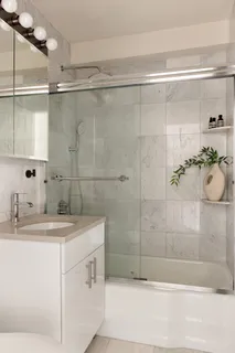 a bathroom with a sink mirror and shower