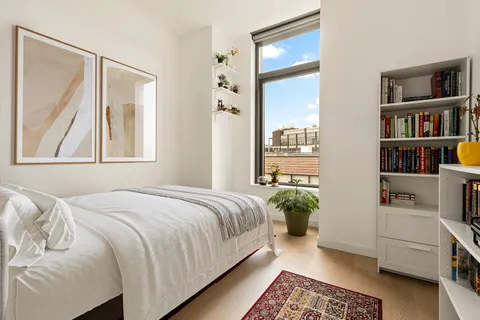 a bedroom with a bed and a book shelf