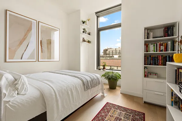 a bedroom with a bed and a book shelf