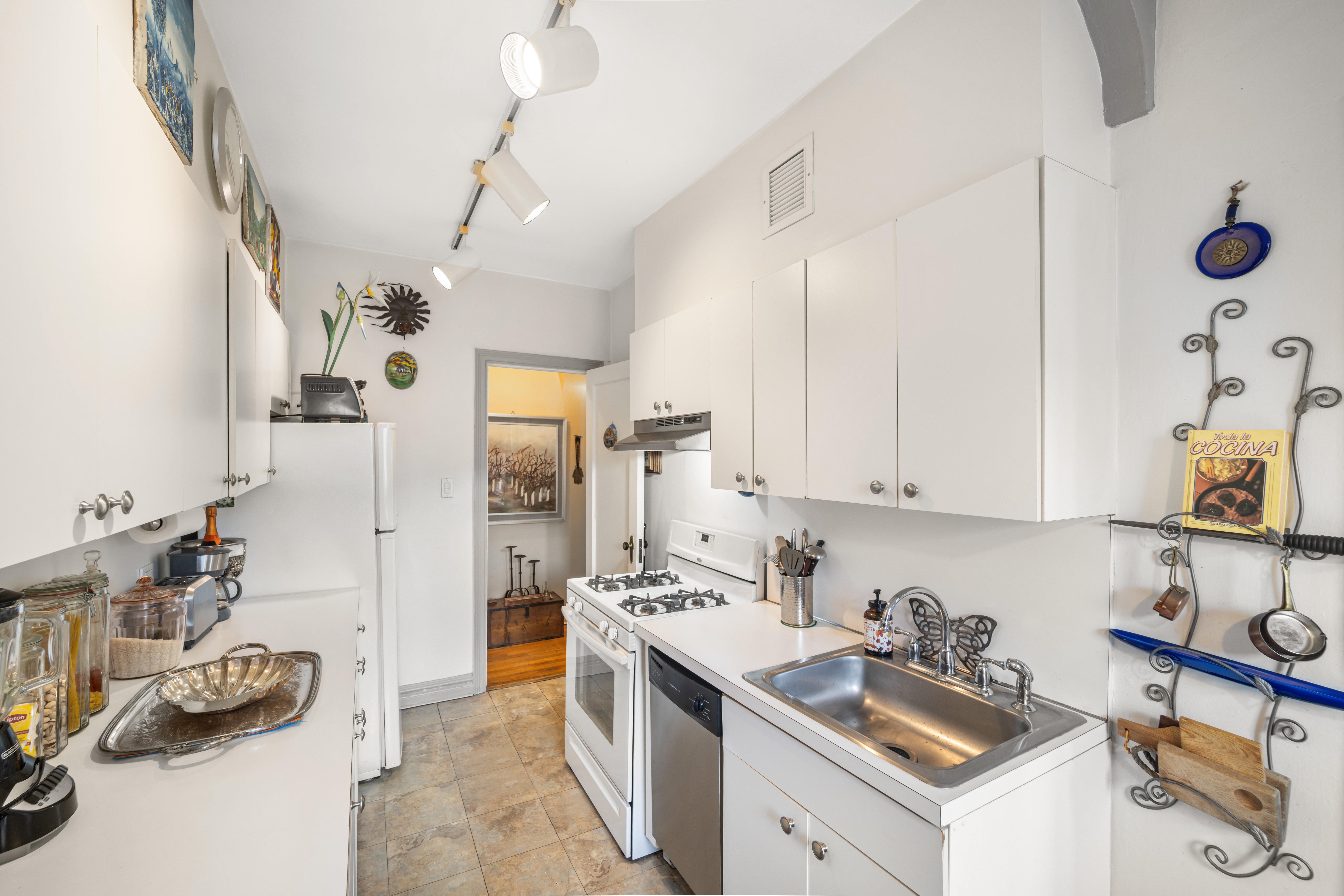 34-24 82nd Street, Unit 6N Queens, NY 11372 - Photo 4 of 15 a kitchen with stainless steel appliances kitchen island granite countertop a sink dishwasher stove and white cabinets with wooden floor