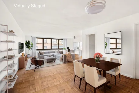 a living room with furniture a rug potted plant and a large window