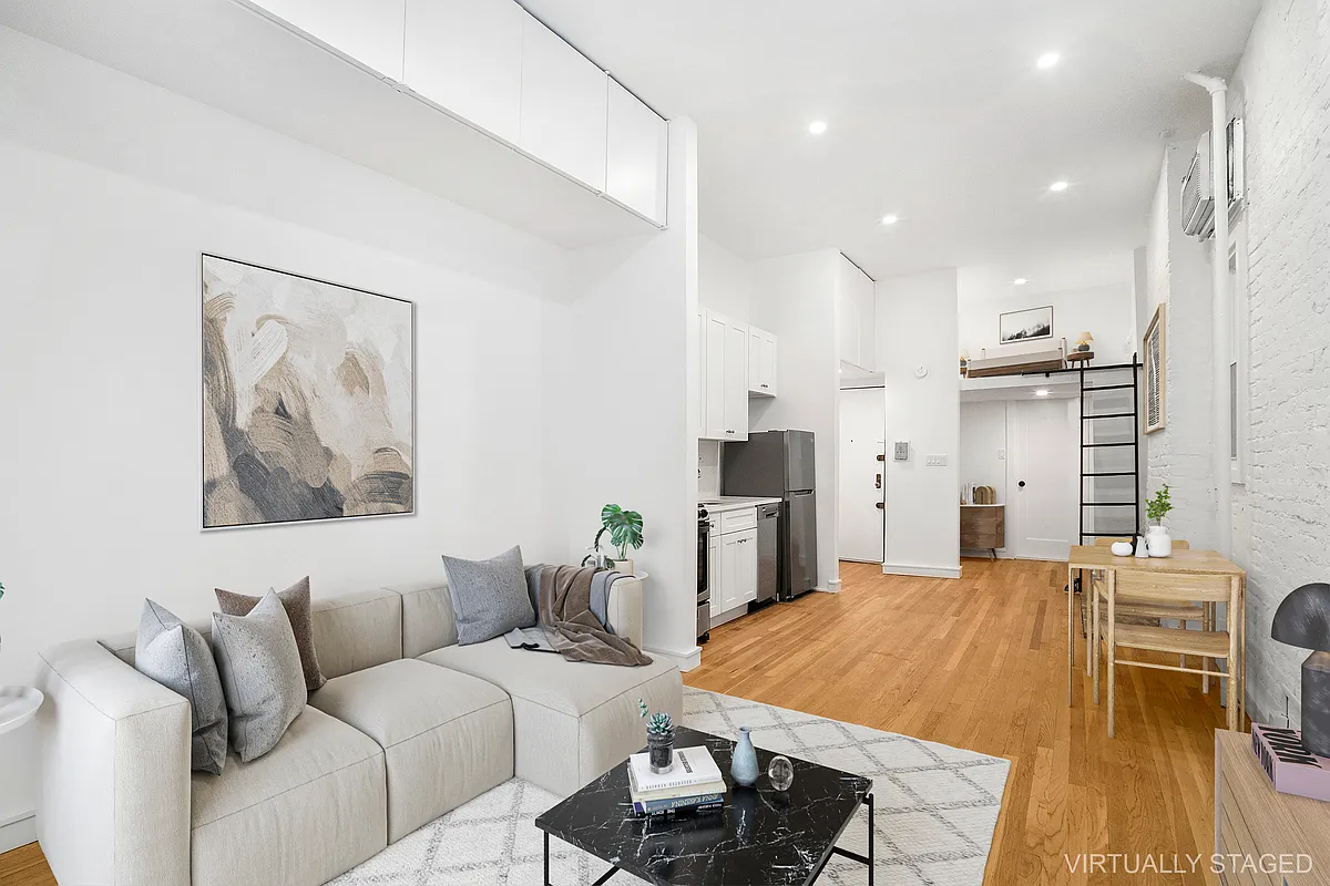 147 Sullivan Street, Unit 1A Manhattan, NY 10012 - Photo 3 of 6 a living room with stainless steel appliances kitchen island granite countertop furniture and a couch