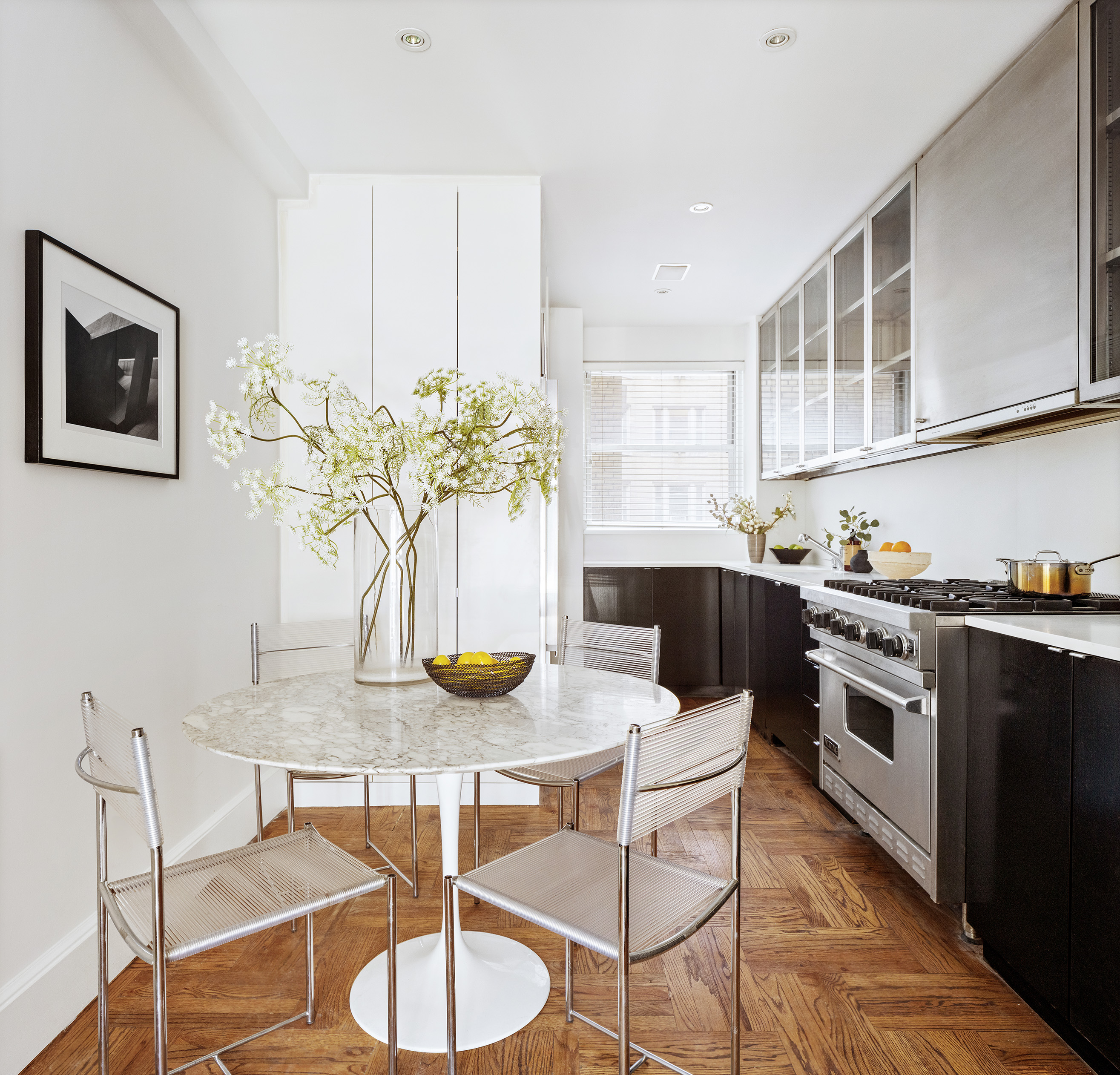 30 5th Avenue, Unit 4F Manhattan, NY 10011 - Photo 4 of 15 a kitchen with stainless steel appliances kitchen island granite countertop a table and chairs in it