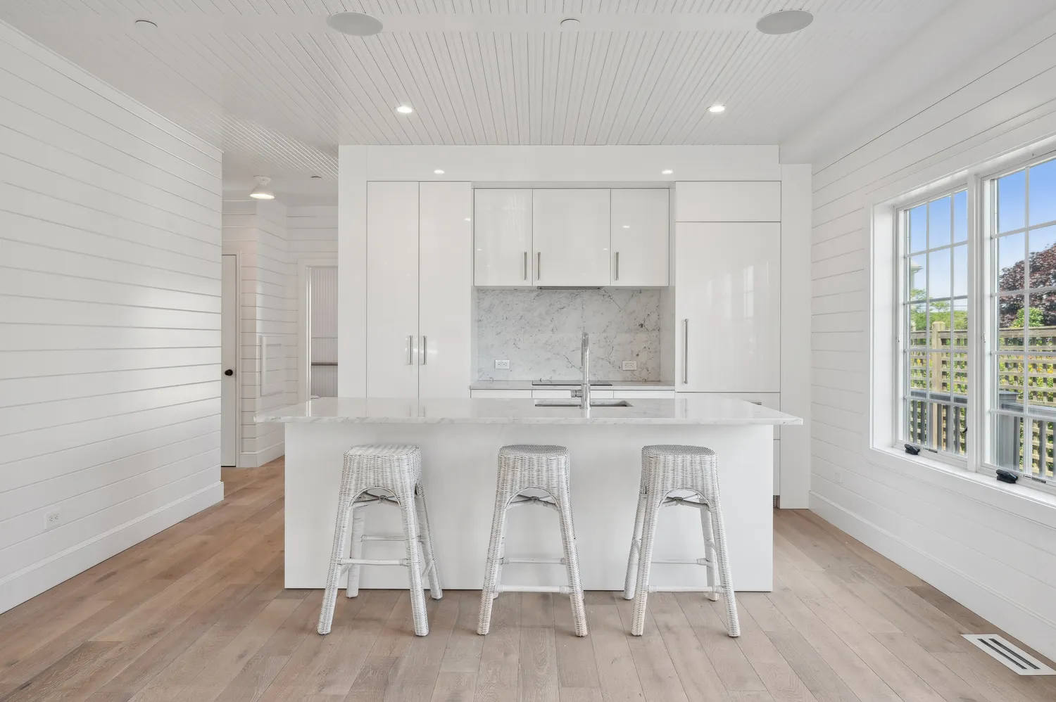 a kitchen with stainless steel appliances white cabinets and wooden floor