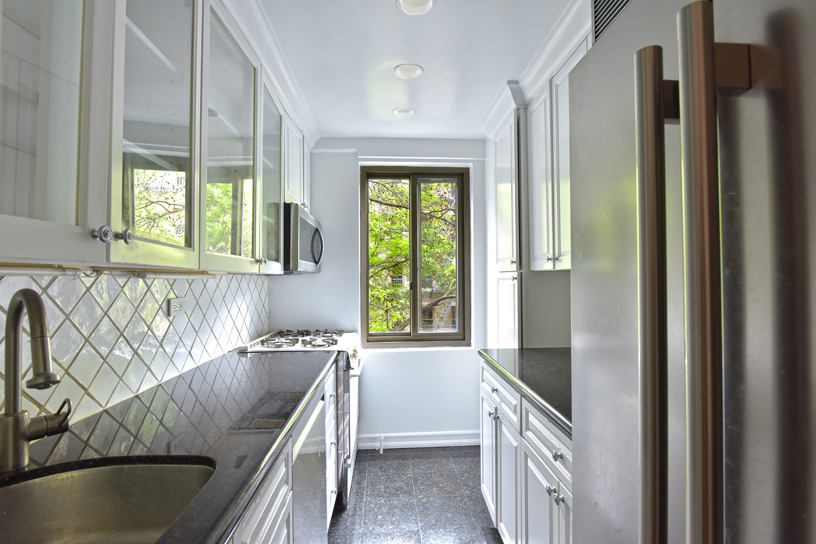 420 East 64th Street, Unit W4D Manhattan, NY 10065 - Photo 9 of 19 a kitchen with stainless steel appliances granite countertop a sink and a granite counter tops with a large window