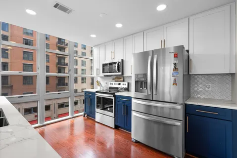 a kitchen with stainless steel appliances granite countertop a sink a stove and a wooden floors