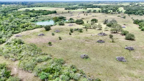 an aerial view of residential houses with outdoor space and trees