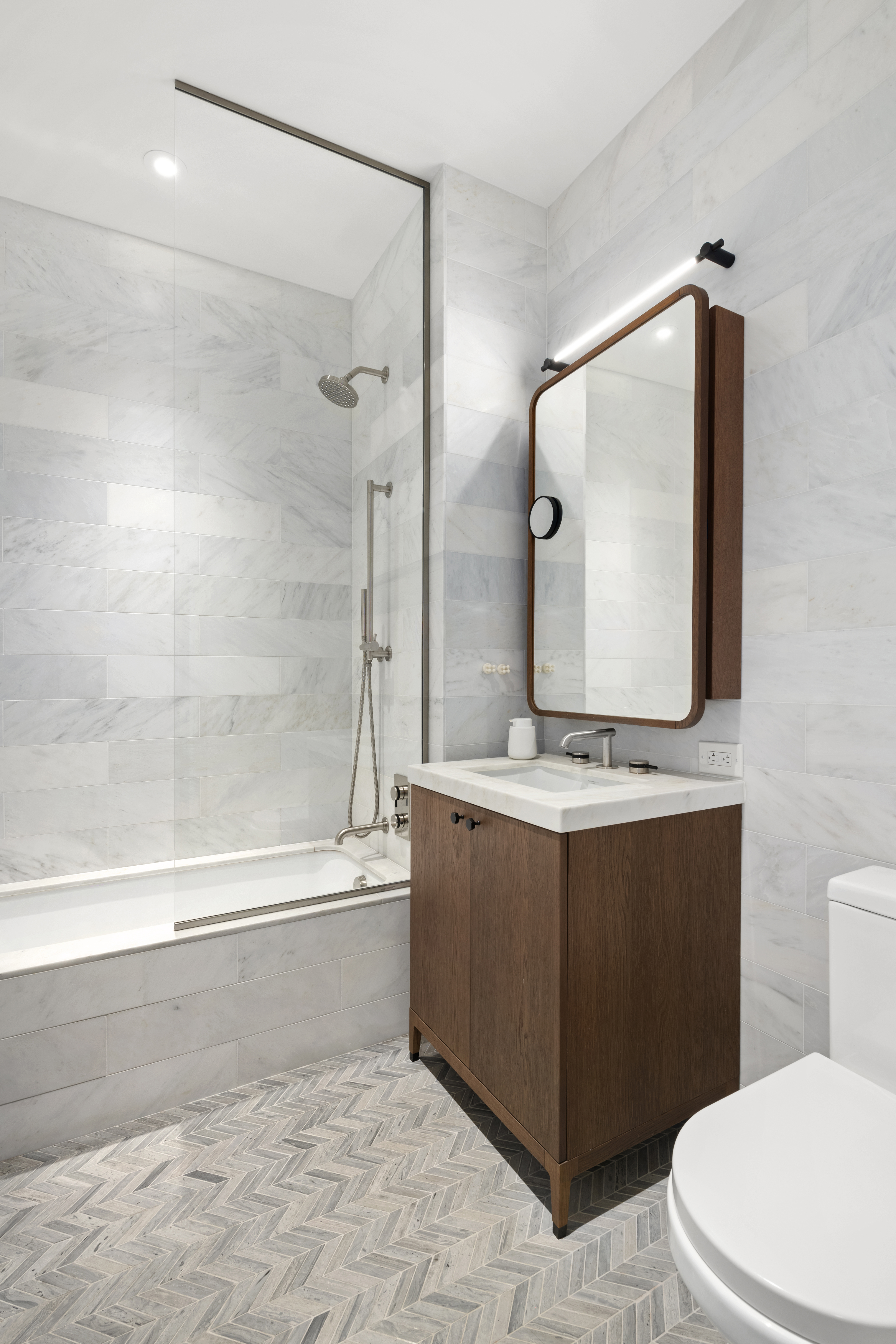 115 York Street, Unit 11C Brooklyn, NY 11201 - Photo 8 of 25 a bathroom with a bathtub sink vanity and toilet