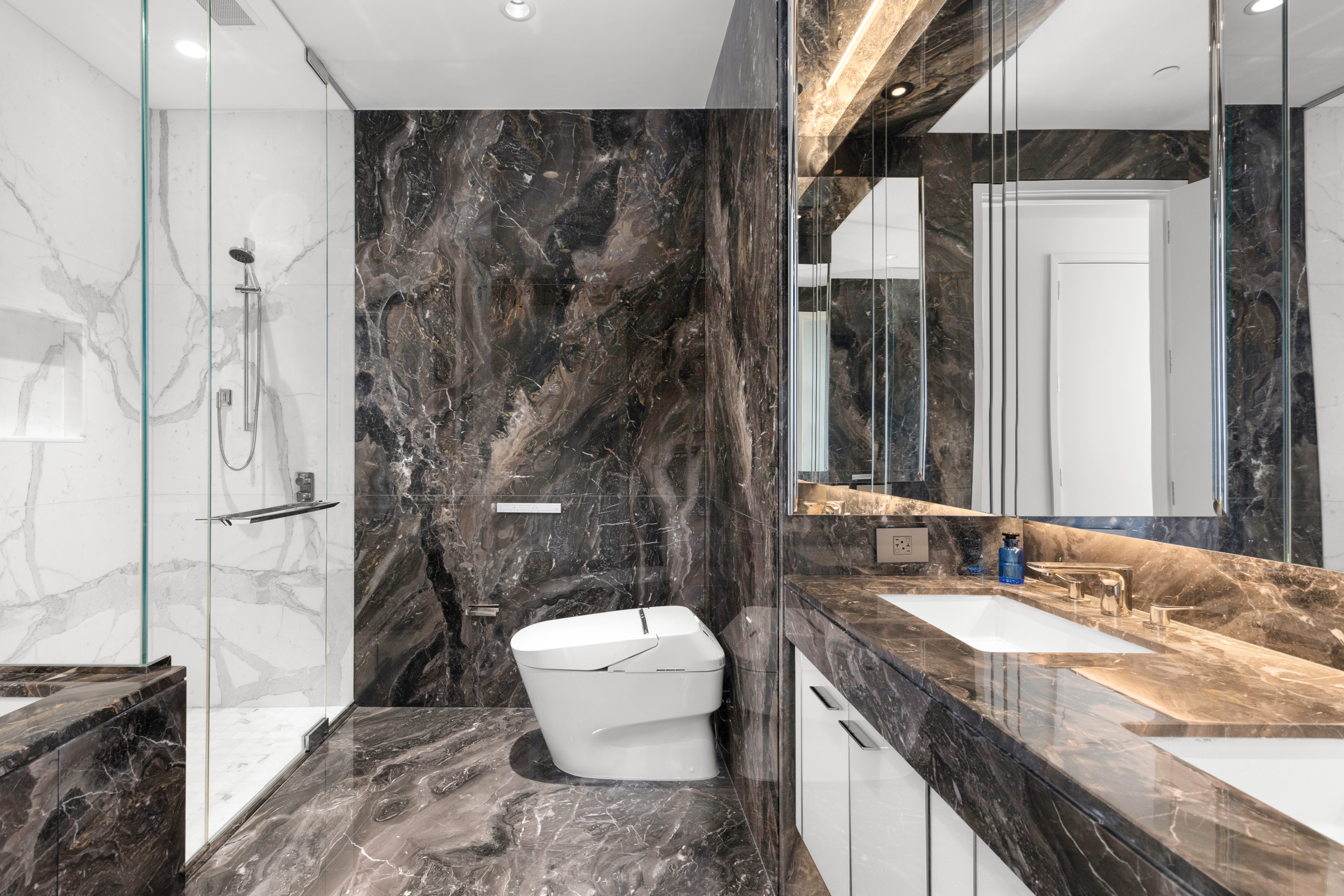 217 West 57th Street, Unit 48D Manhattan, NY 10019 - Photo 5 of 17 a bathroom with a granite countertop sink toilet and shower