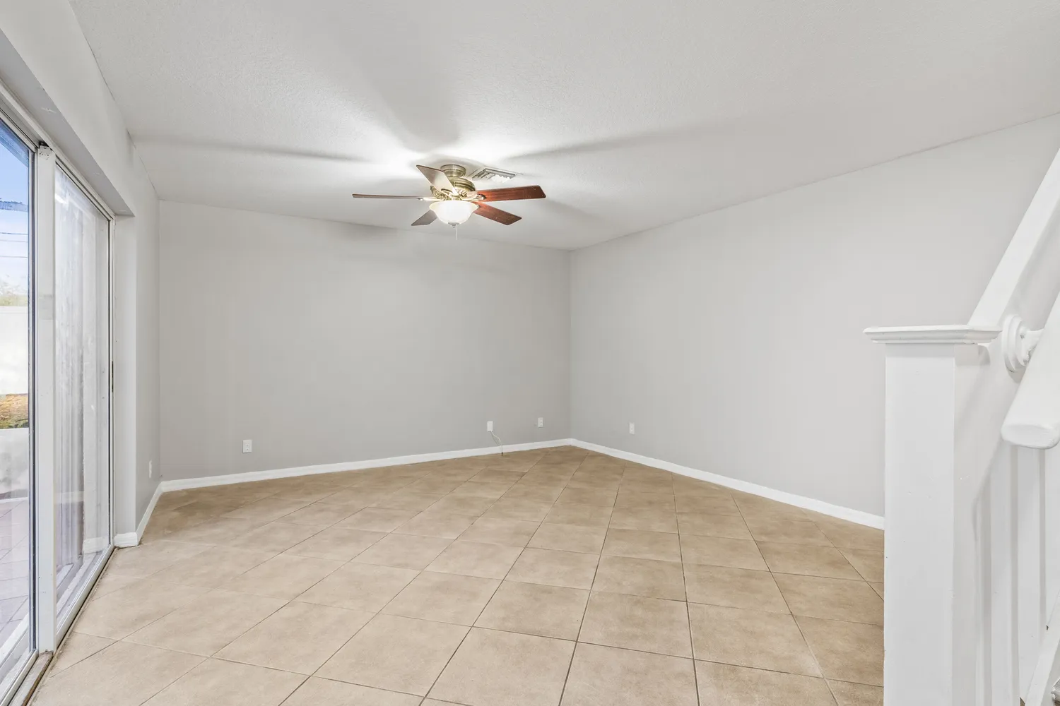an empty room with a ceiling fan and a window