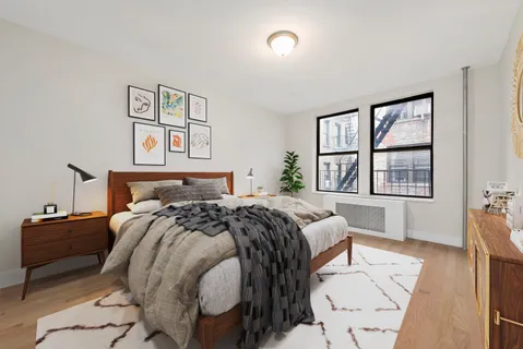 a bed sitting in a bedroom next to a window