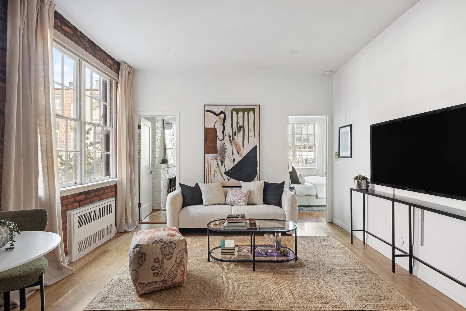 a living room with furniture a flat screen tv and a large window