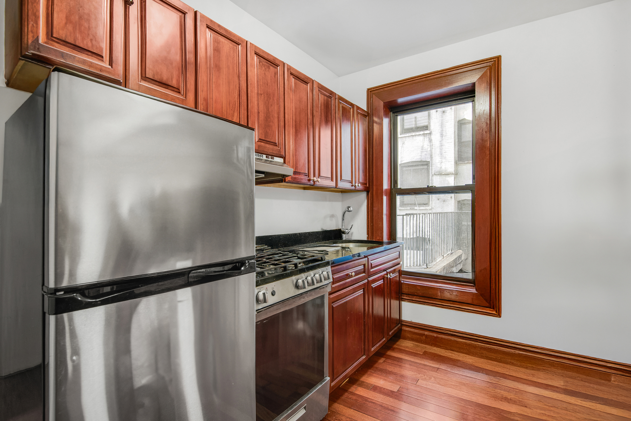 1392 Madison Avenue, Unit 28 Manhattan, NY 10128 - Photo 1 of 10 a kitchen with stainless steel appliances granite countertop a refrigerator a stove and a window