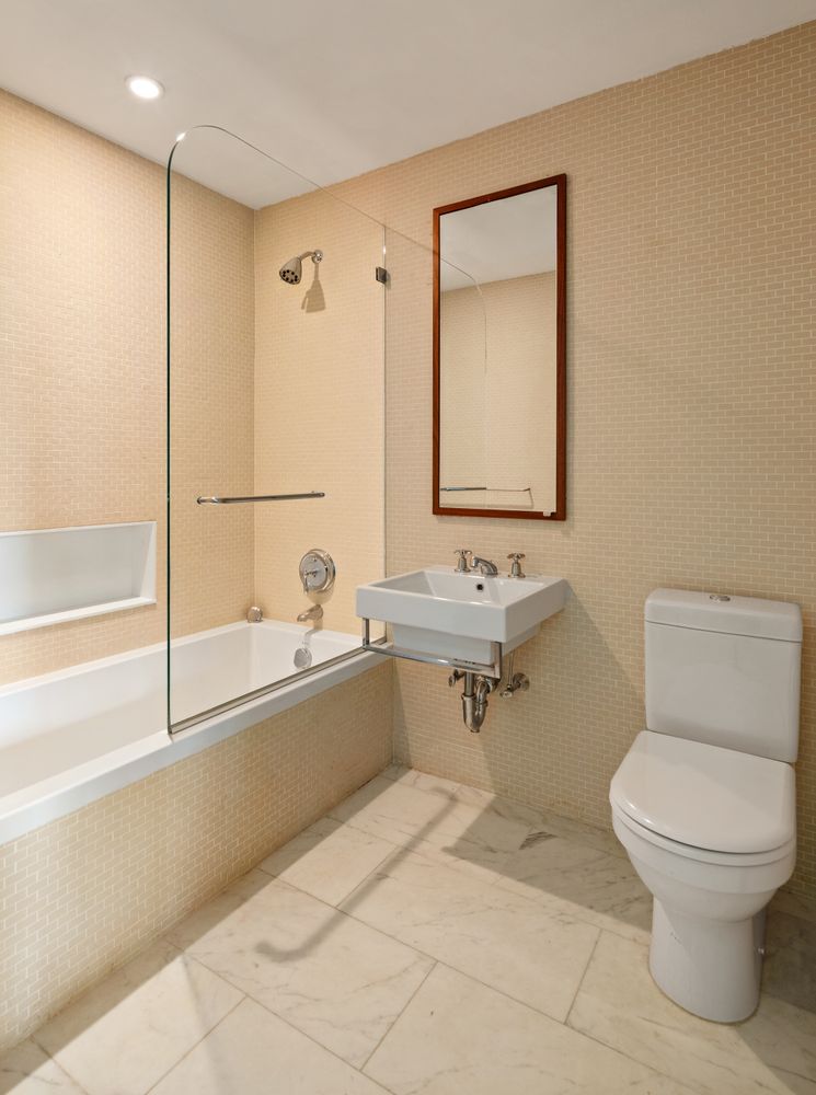 456 West 19th Street, Unit 6/7F Manhattan, NY 10011 - Photo 11 of 13 a bathroom with a toilet a sink and a bathtub