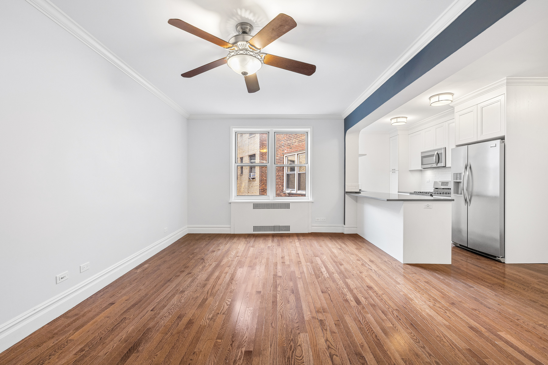 73-12 35th Avenue, Unit D56 Queens, NY 11372 - Photo 2 of 15 a view of a kitchen with wooden floor and a kitchen