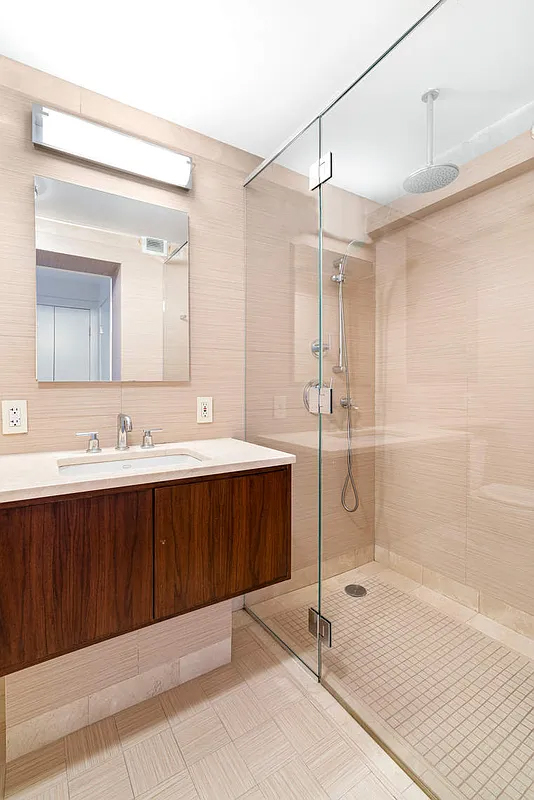 333 East 66th Street, Unit 2FE Manhattan, NY 10065 - Photo 8 of 19 a spacious bathroom with a shower sink and mirror