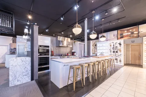 a kitchen with stainless steel appliances kitchen island granite countertop a stove a sink and a refrigerator