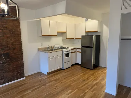 a kitchen with a refrigerator sink and cabinets