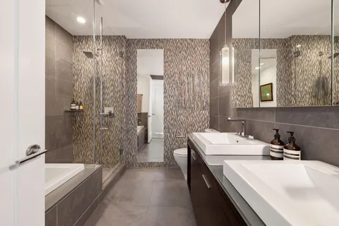a bathroom with a double vanity sink mirror and shower