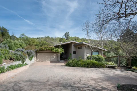 a front view of a house with a yard and trees