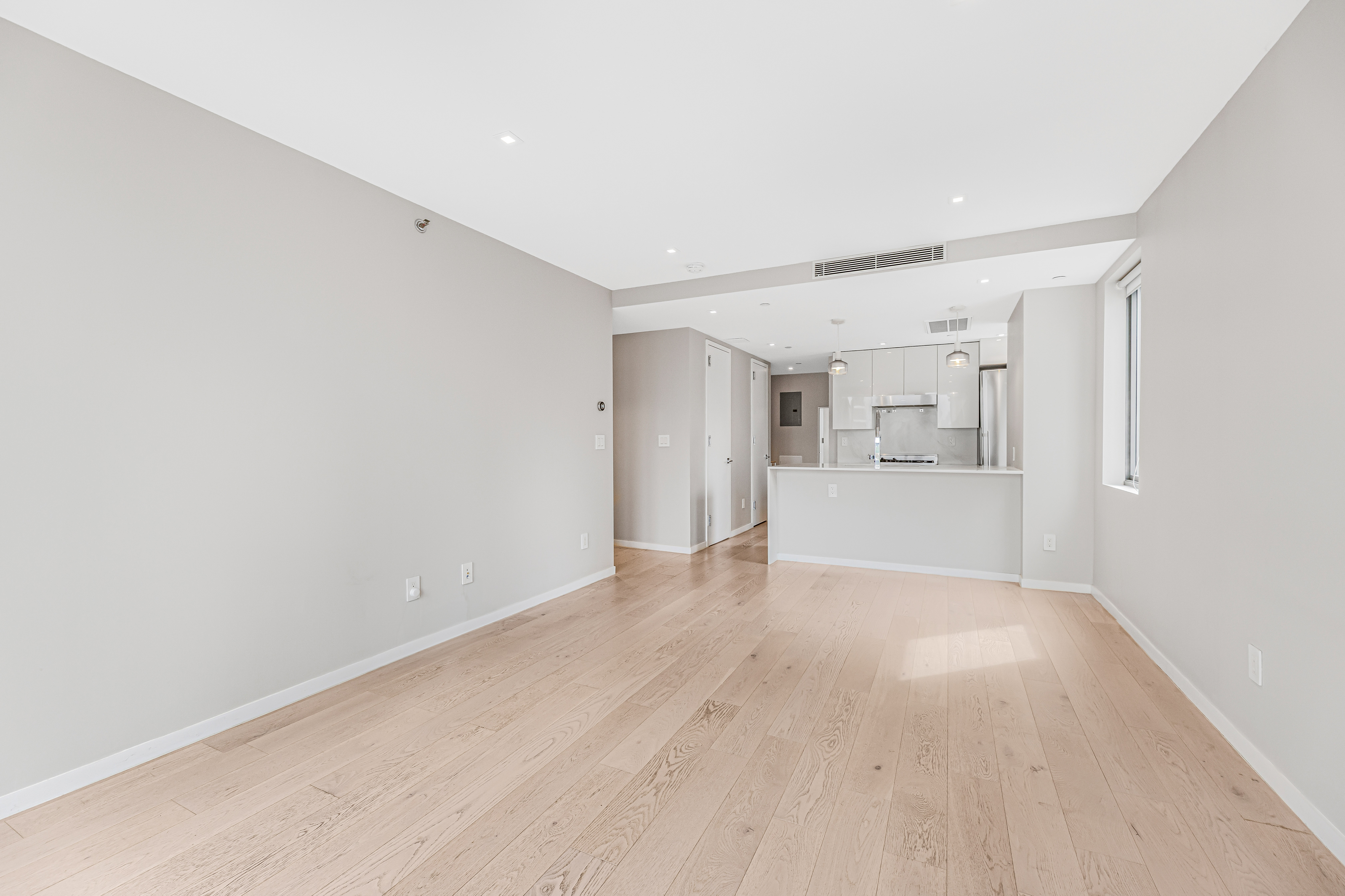 42-50 27th Street, Unit 9C Queens, NY 11101 - Photo 19 of 32 a view of a big room with wooden floor and windows