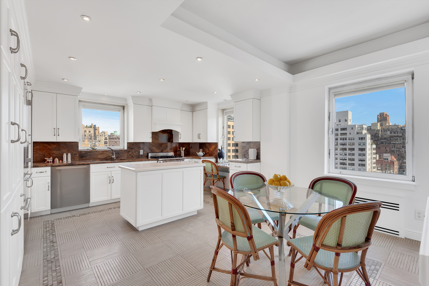 936 5th Avenue, Unit 14B Manhattan, NY 10021 - Photo 3 of 15 a kitchen with stainless steel appliances granite countertop a table and chairs