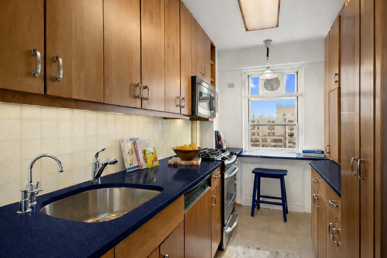 70 East 10th Street, Unit 20C Manhattan, NY 10003 - Photo 11 of 24 a kitchen with granite countertop a sink a stove and cabinets