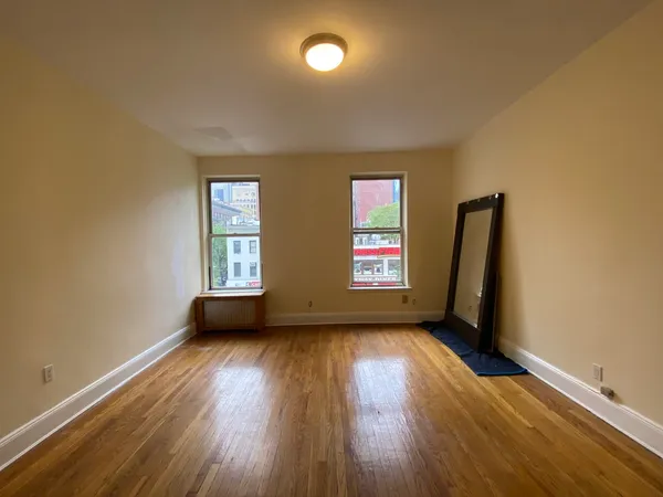 an empty room with windows and wooden floor