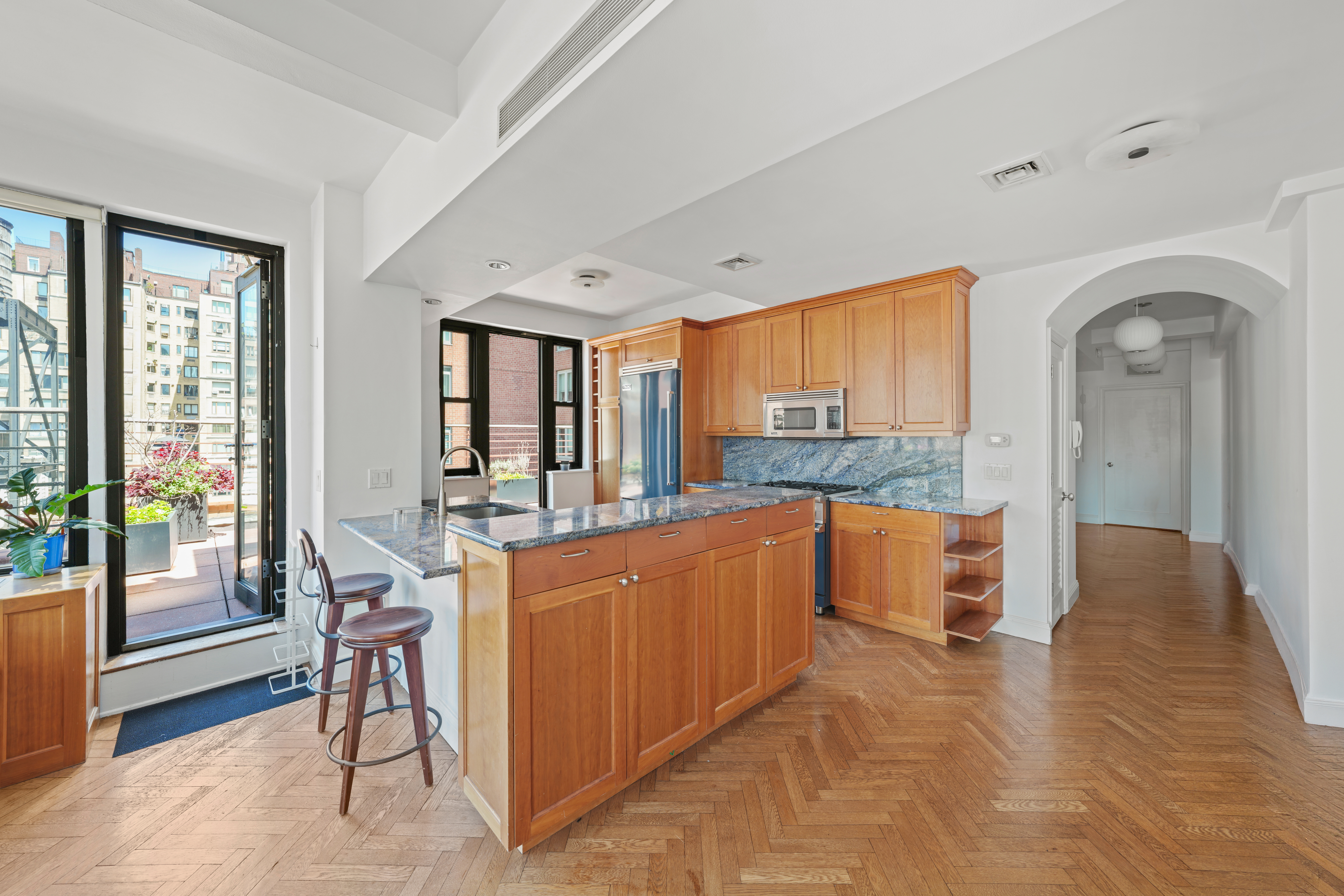 177 East 77th Street, Unit PHC Manhattan, NY 10075 - Photo 6 of 26 a large kitchen with stainless steel appliances a large counter top and a large window