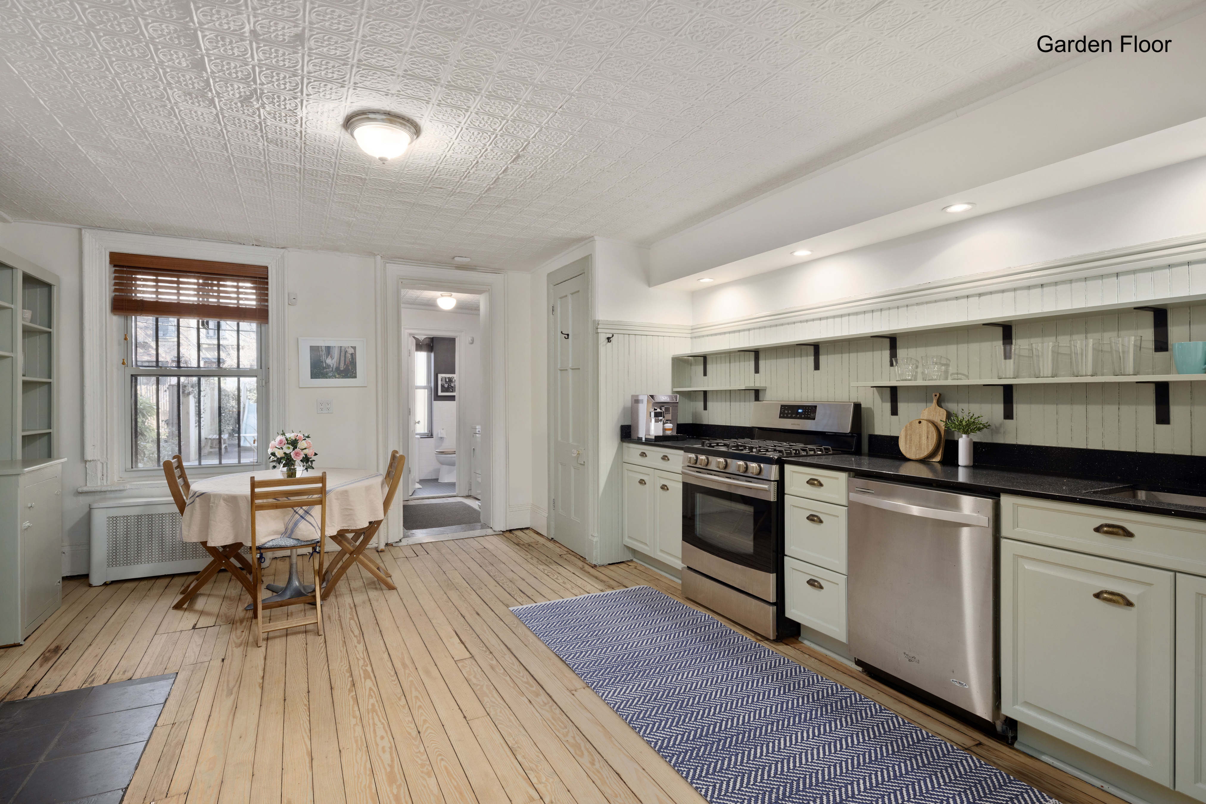 20 Strong Place Brooklyn, NY 11231 - Photo 5 of 21 a kitchen with stainless steel appliances granite countertop a stove top oven a sink dishwasher white cabinets and a dining table with wooden floor