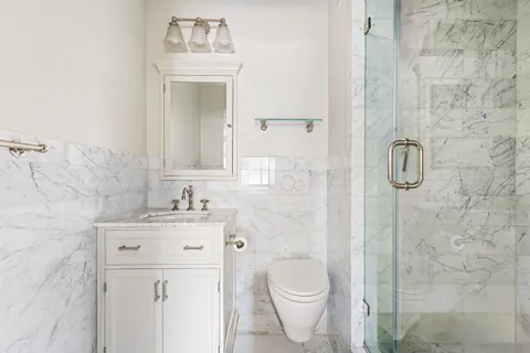 a bathroom with a granite countertop bathtub sink vanity mirror and toilet