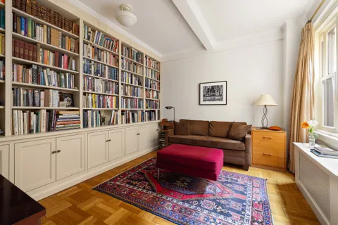 a living room with furniture and a book shelf