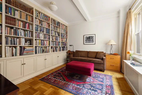 a living room with furniture and a book shelf