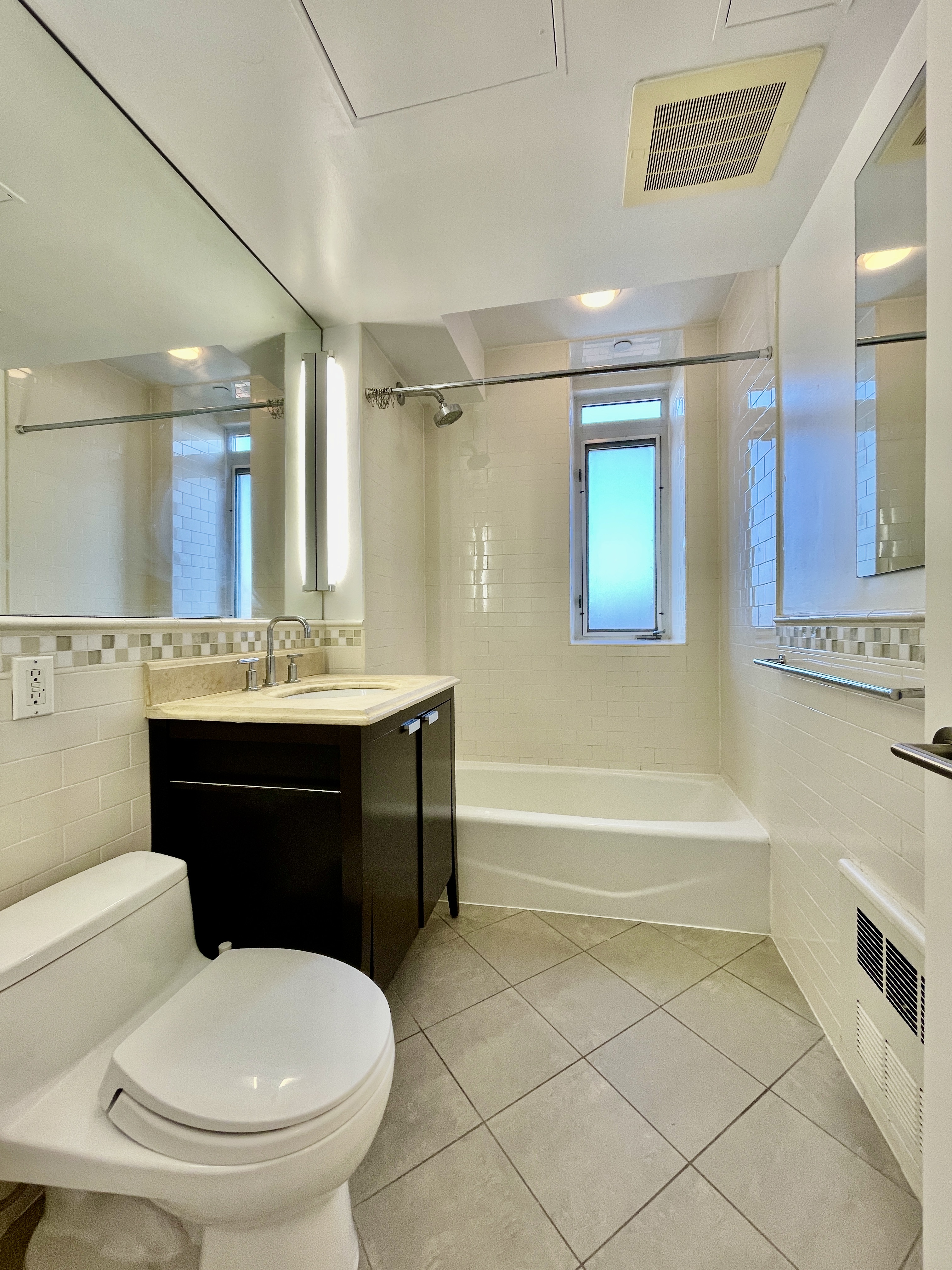 106 West 116th Street, Unit 12A Manhattan, NY 10026 - Photo 7 of 13 a bathroom with a sink a toilet and a bathtub