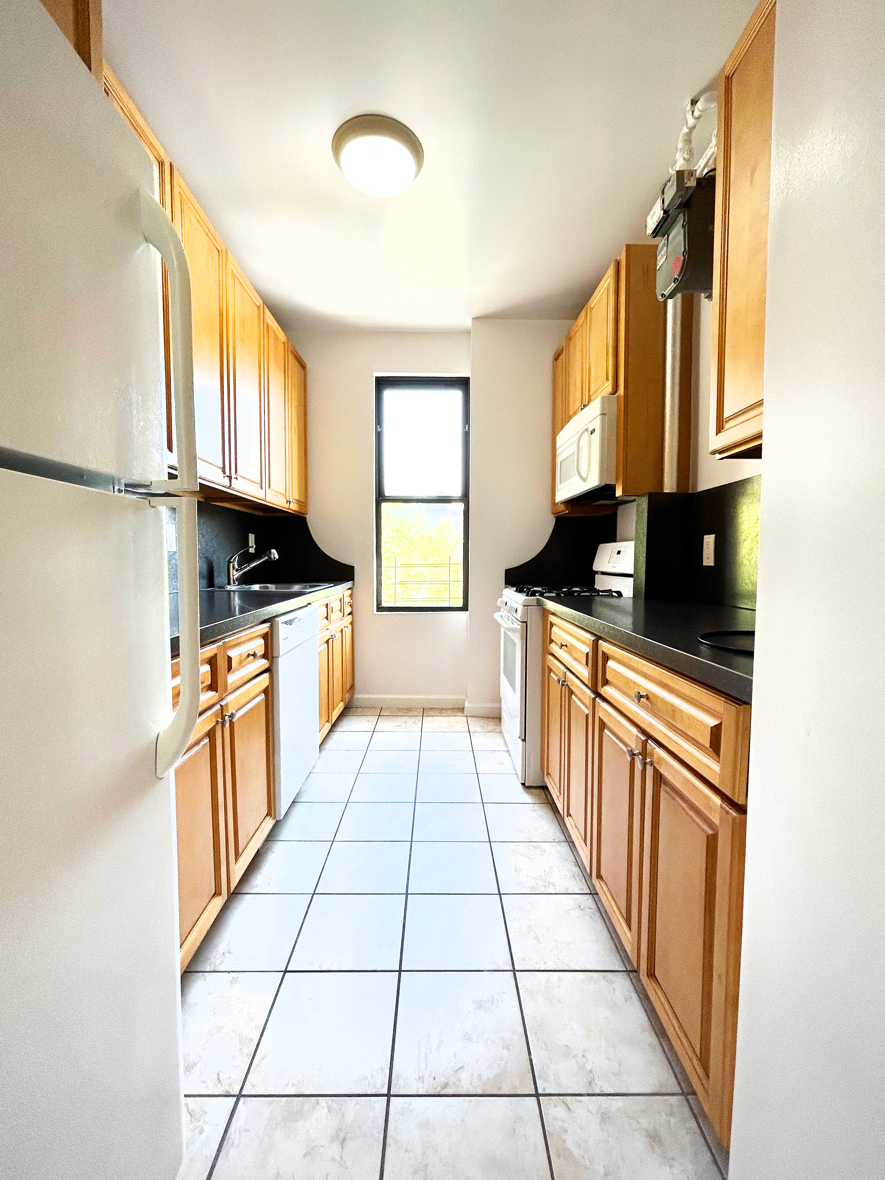 620 West 171st Street, Unit 3B Manhattan, NY 10032 - Photo 3 of 9 a kitchen with stainless steel appliances granite countertop a stove a sink and a microwave