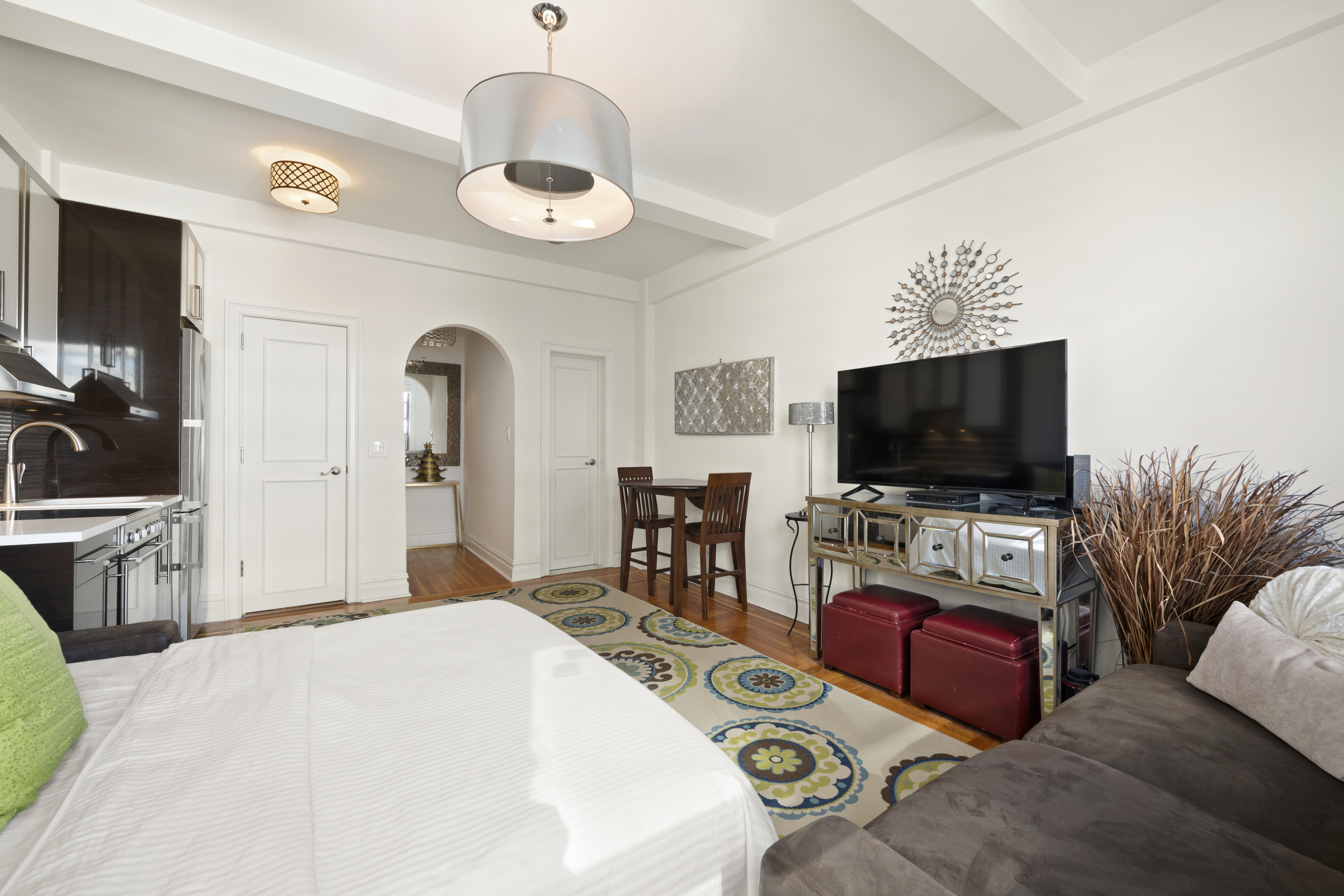 20 West 72nd Street, Unit 1600 Manhattan, NY 10023 - Photo 2 of 7 a living room with furniture and a flat screen tv