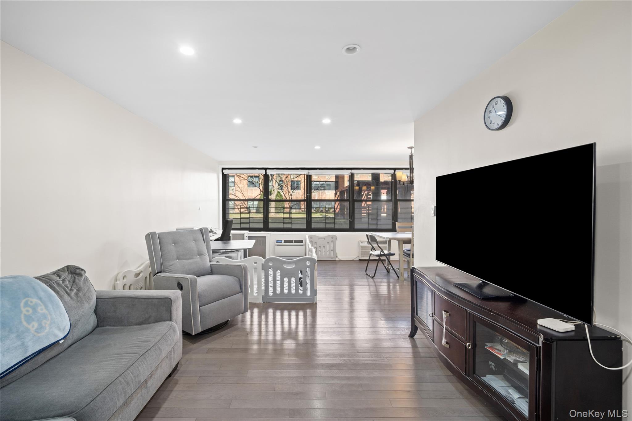 75-34 Bell Boulevard, Unit LD Queens, NY 11364 - Photo 8 of 26 a living room with furniture and a flat screen tv