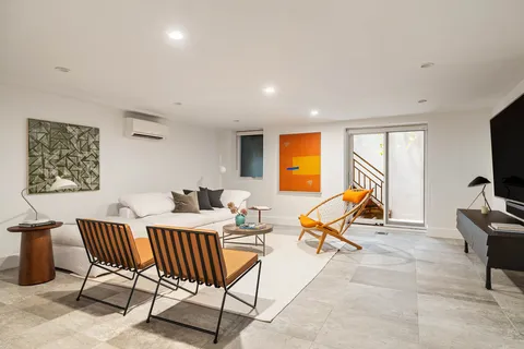 a living room with furniture a air conditioner vent and a window