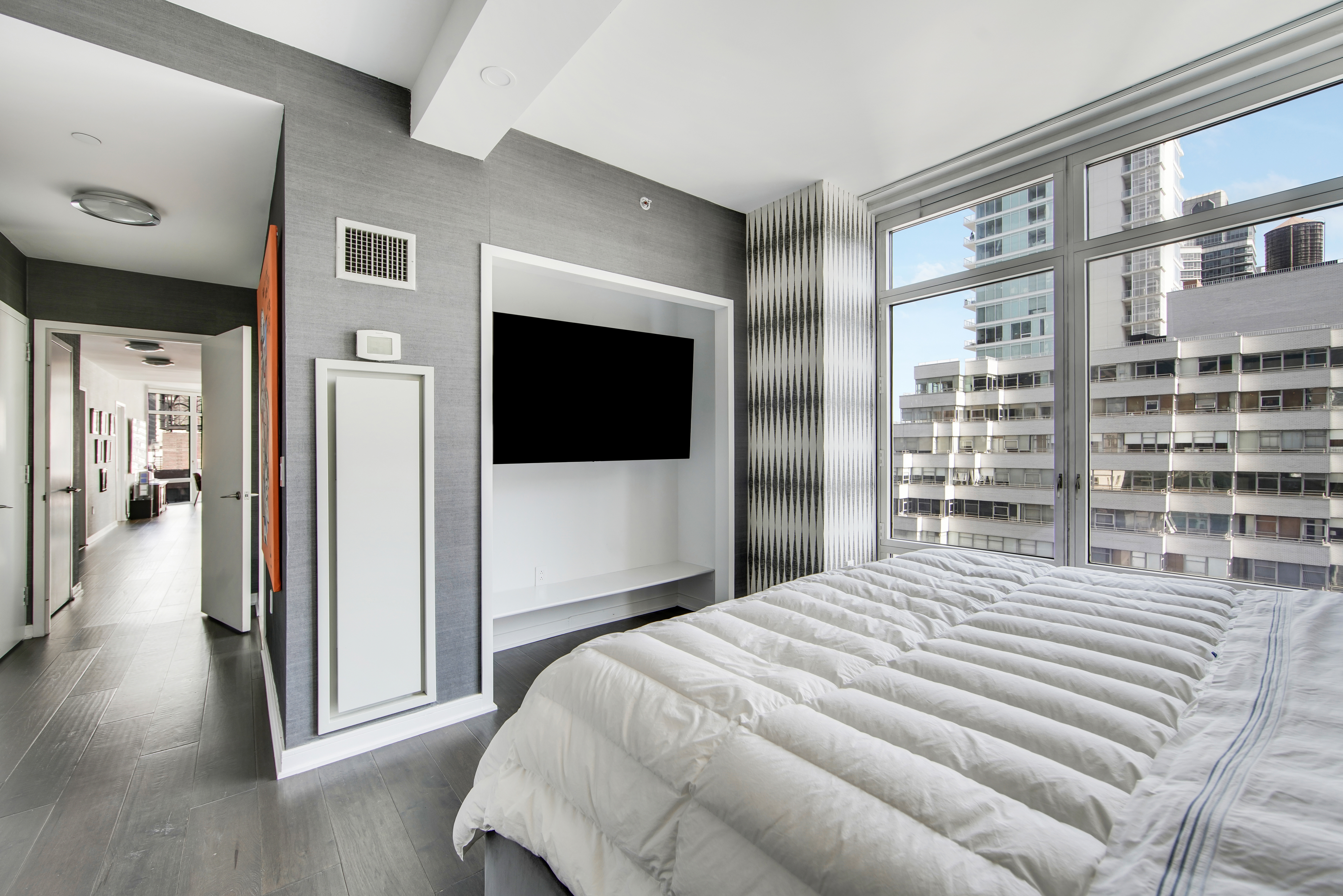 207 East 57th Street, Unit 20A Manhattan, NY 10022 - Photo 10 of 18 a bedroom with a bed and a flat screen tv