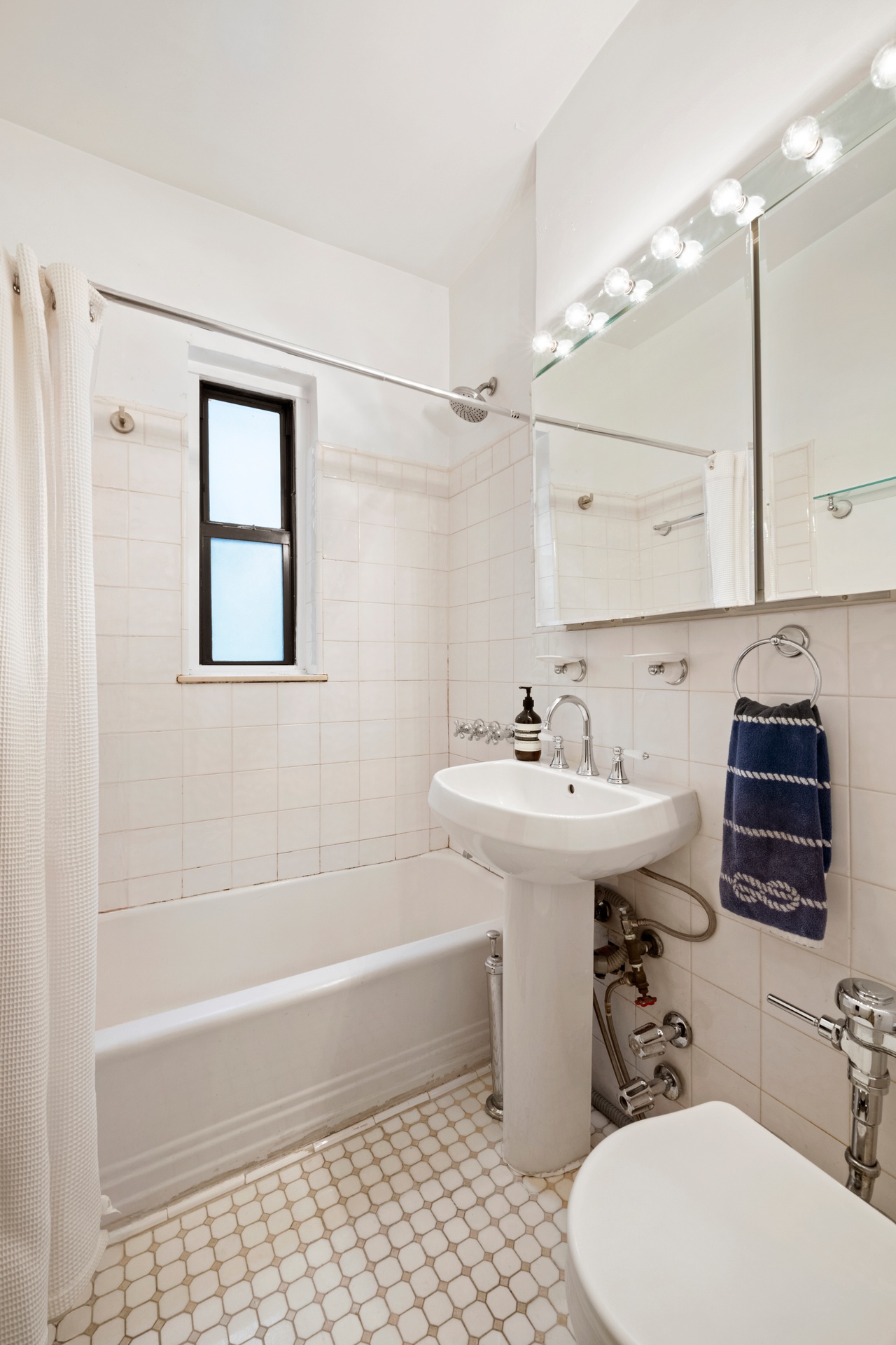 62 East 87th Street, Unit 3C Manhattan, NY 10128 - Photo 6 of 7 a bathroom with a sink toilet and shower