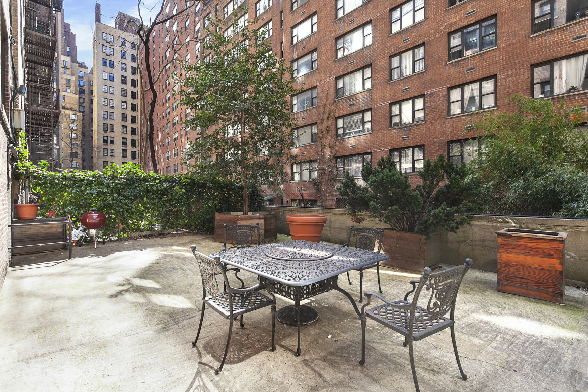 410 East 57th Street, Unit 15BE Manhattan, NY 10022 - Photo 16 of 18 a view of a brick building with a bench and table chair