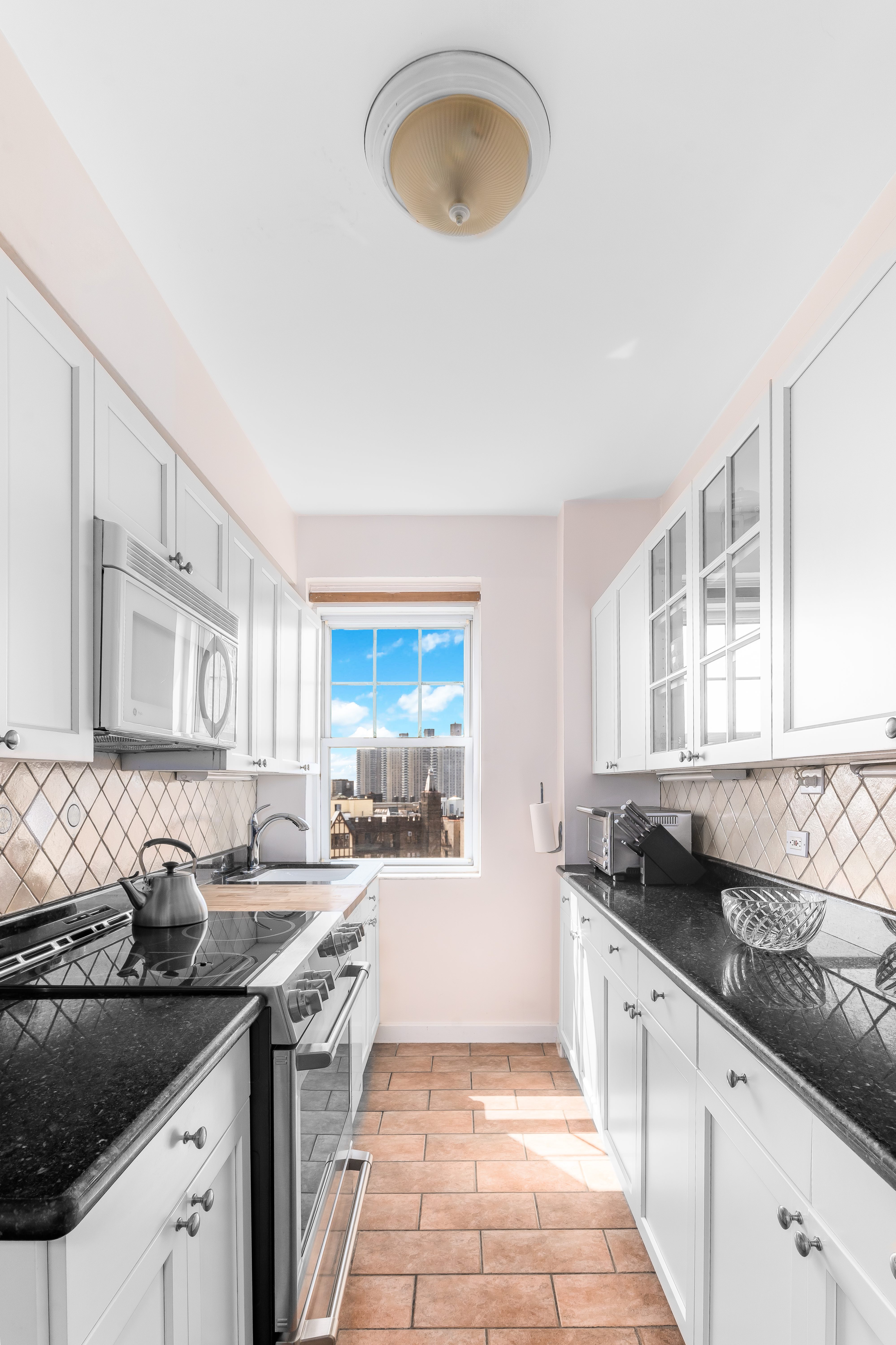 140 Cabrini Boulevard, Unit 136 Manhattan, NY 10033 - Photo 8 of 33 a kitchen with granite countertop a sink and a stove