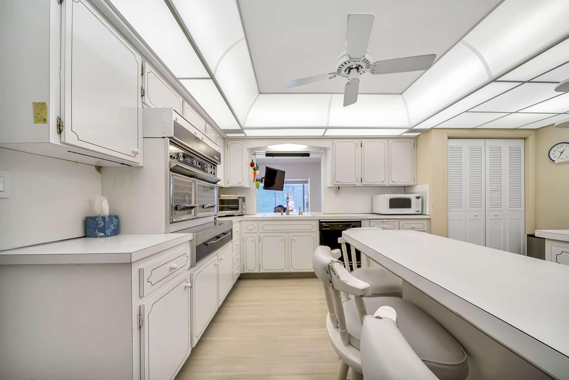 6760 Southwest 62nd Terrace Miami, FL 33143 - Photo 26 of 38 a kitchen with a sink dishwasher stove and white cabinets with wooden floor