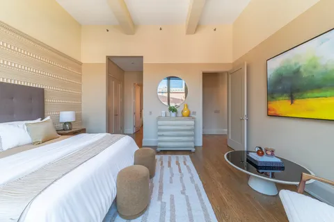 a bedroom with a bed and wooden floor