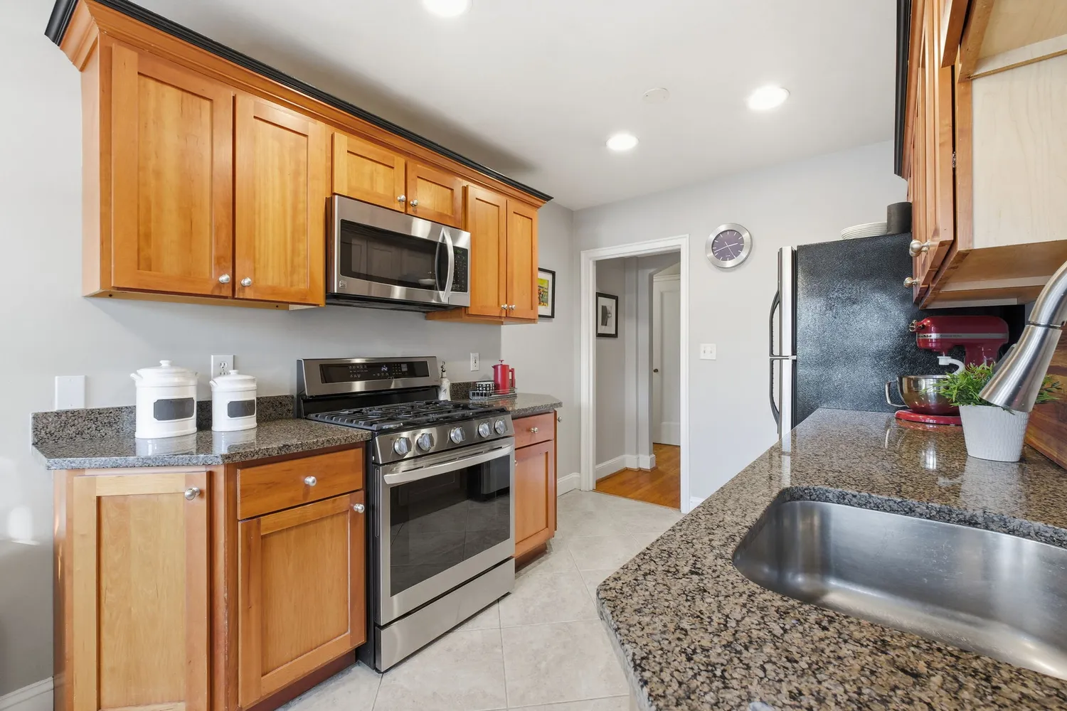 a kitchen with stainless steel appliances granite countertop a sink stove and refrigerator