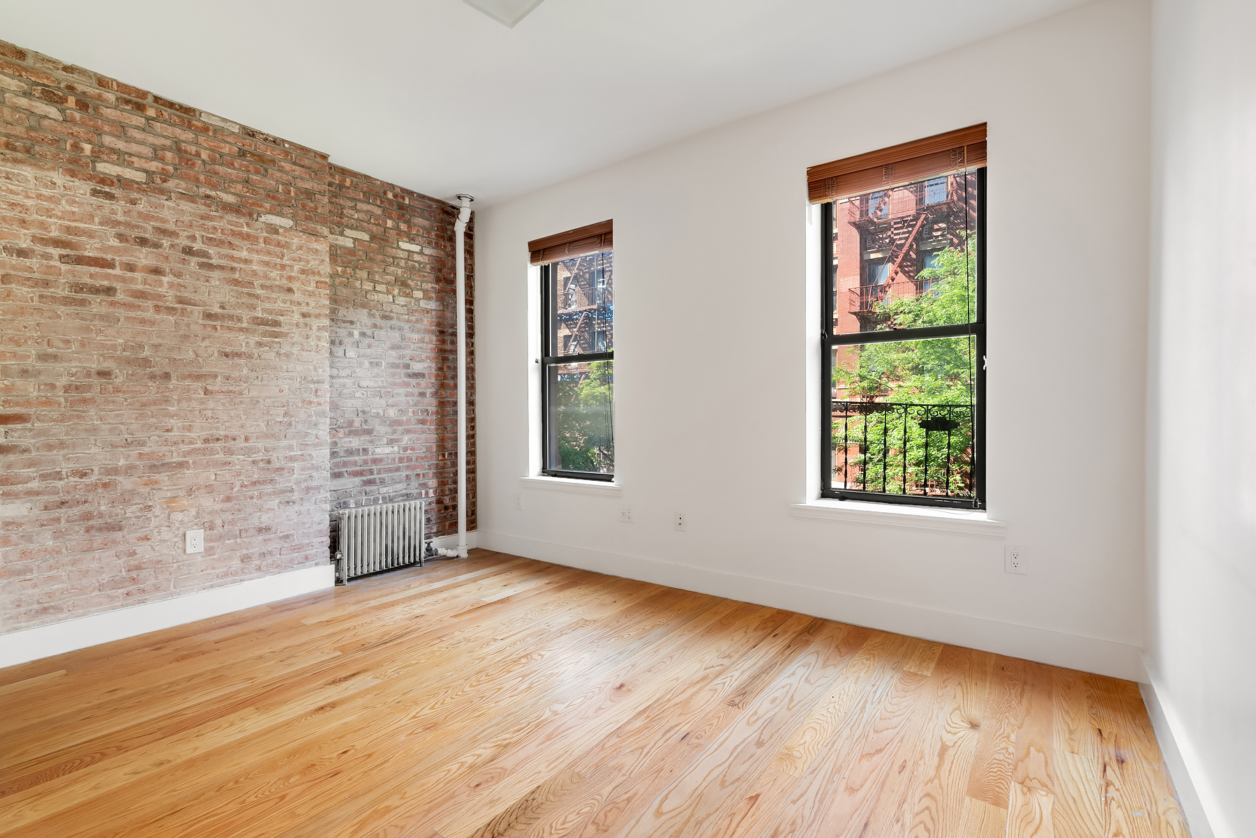 143 West 4th Street, Unit 2FE Manhattan, NY 10012 - Photo 4 of 4 a view of an empty room with wooden floor and a window