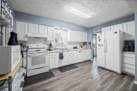 a kitchen with white cabinets and white appliances