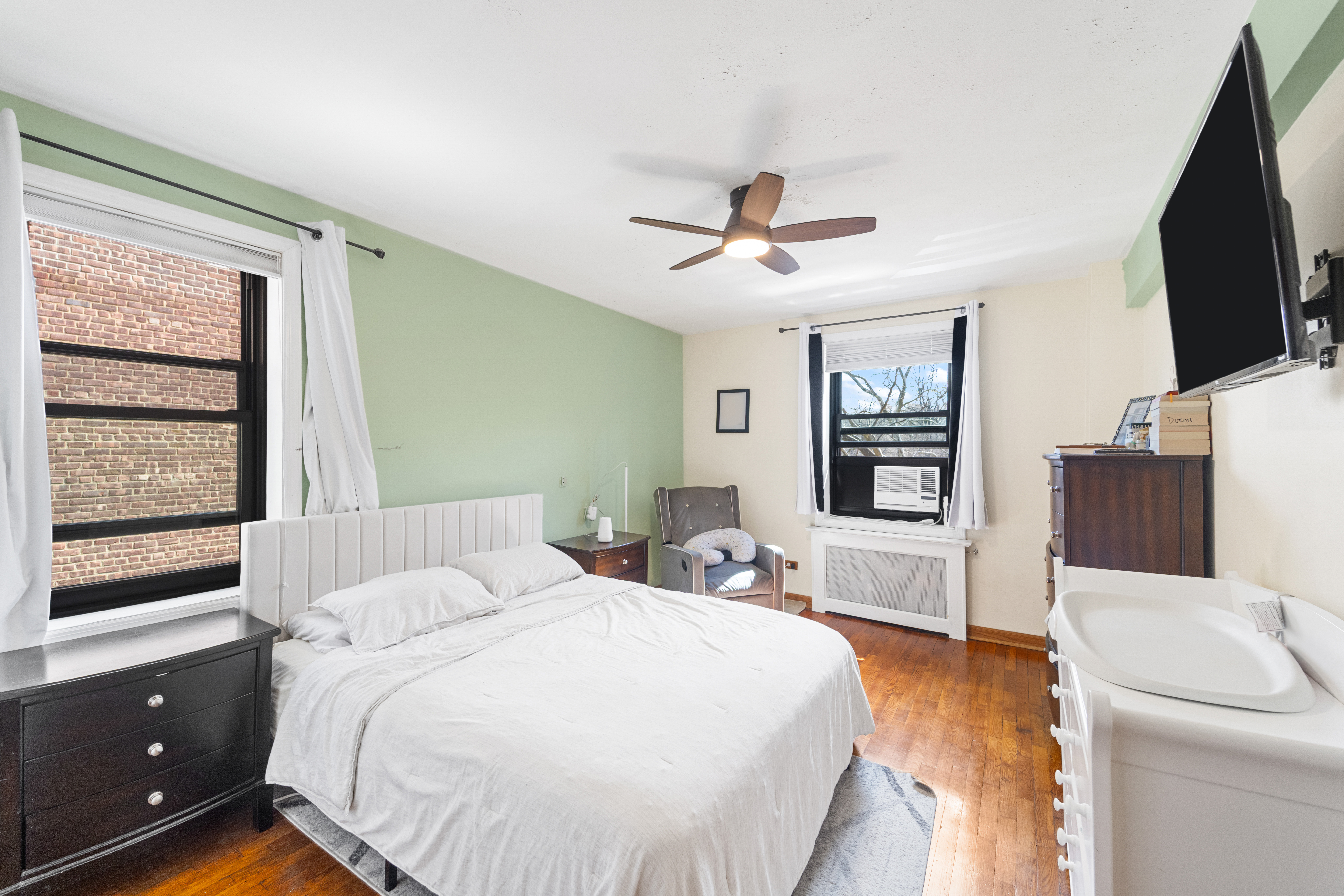 211-01 75th Avenue, Unit 4O Queens, NY 11364 - Photo 6 of 19 a bedroom with a bed a window and a flat screen television