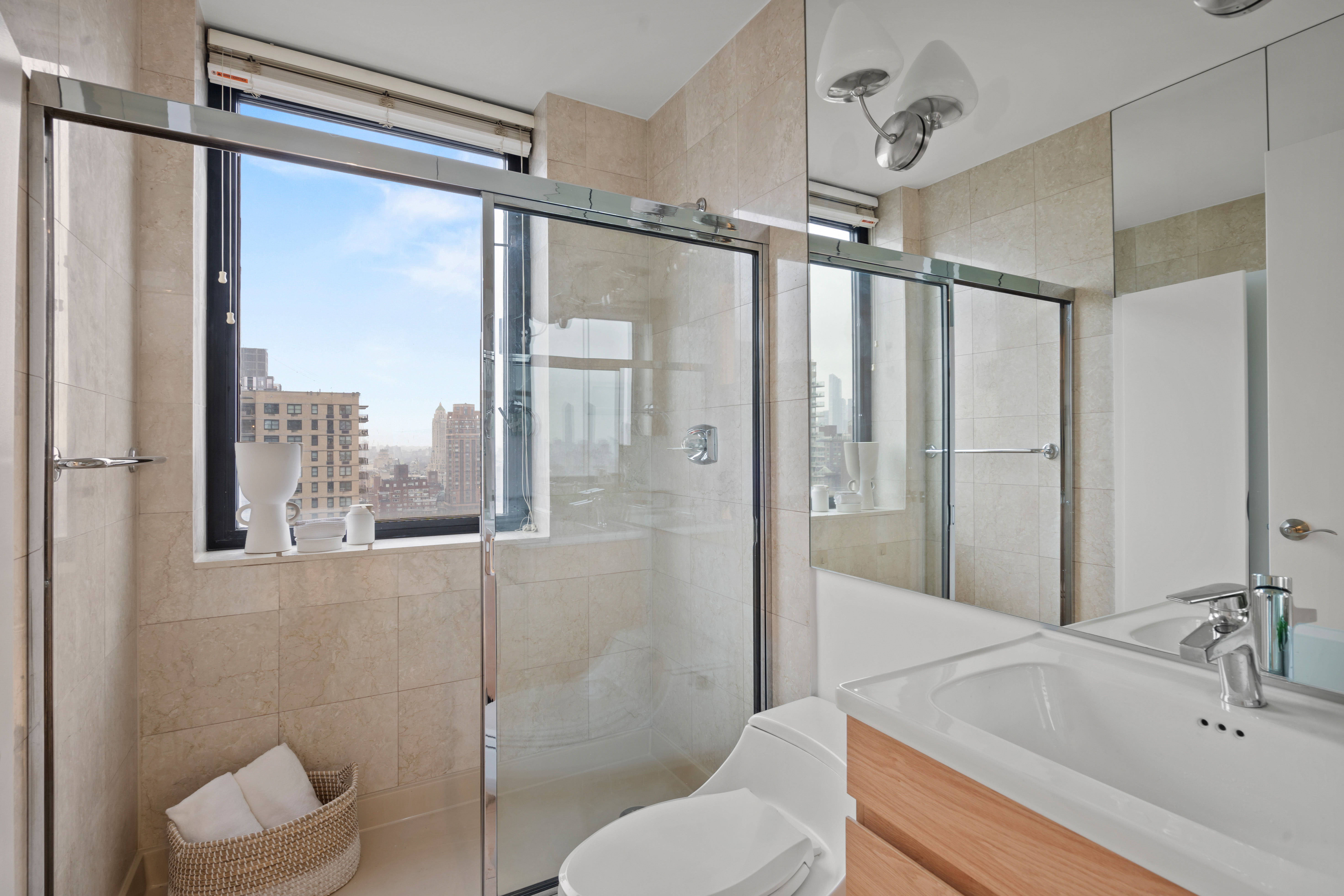 330 East 75th Street, Unit 32A Manhattan, NY 10021 - Photo 13 of 17 a bathroom with a sink mirror and a shower