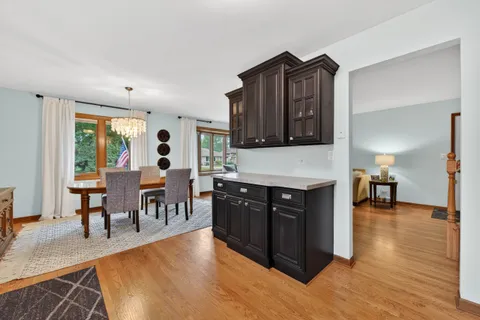 a living room with stainless steel appliances kitchen island granite countertop furniture a fireplace and a dining table next to a window